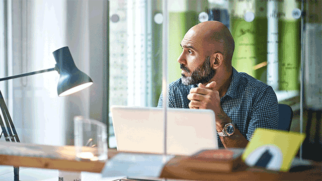 Man funderar framför datorn