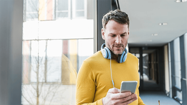 Kille med mobil och hörlurar