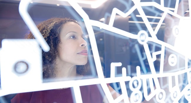 Kvinna ser genom ett fönster med mönster