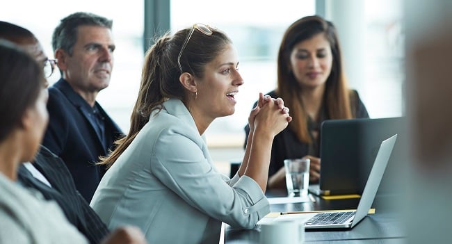 Framåtlutad kvinna på kontorsmöte