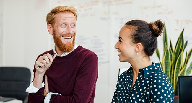 Glad man och kvinna på arbetsplats