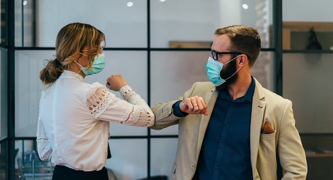 Kvinna och man hälsar med armbågen