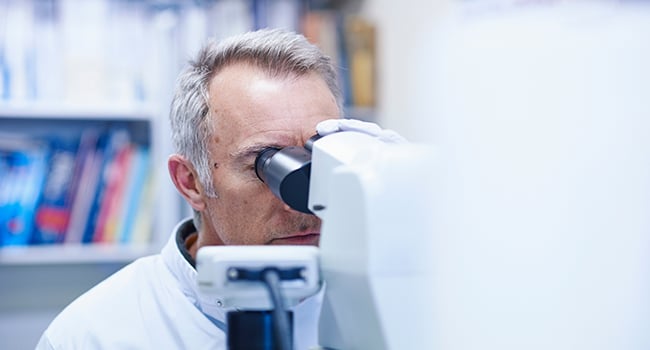 Man tittar i mikroskop 
