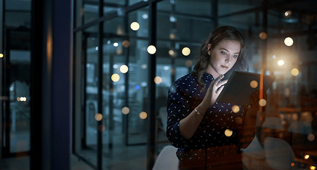 Kvinna på kontor med surfplatta