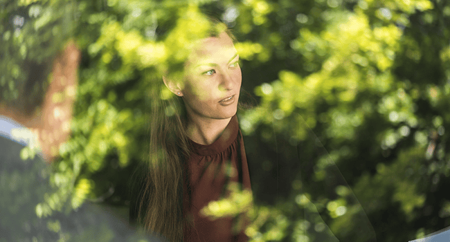 Kvinna vid grön buske