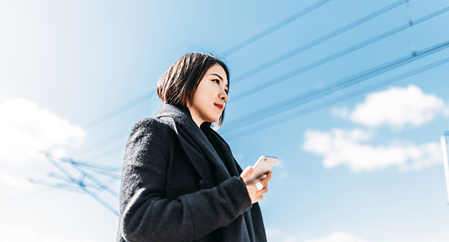 Kvinna med mobiltelefon vid elledning