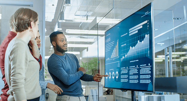 Medarbetare ser på skärm med grafer