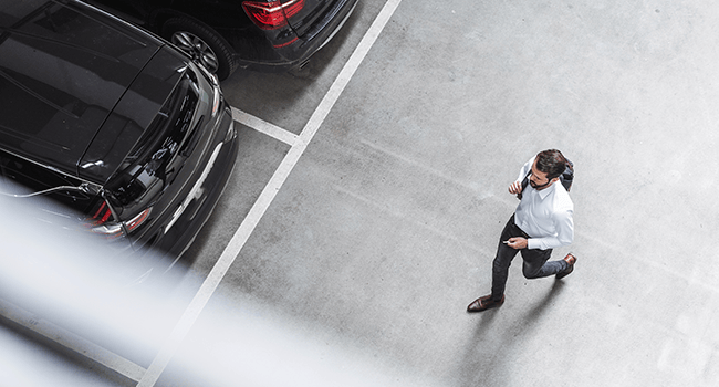 Man går på bilparkering