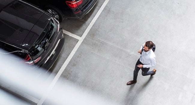 Man går på en bilparkering