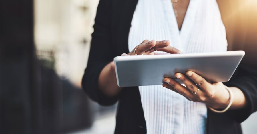 Närbild på en persons händer som håller i en läsplatta