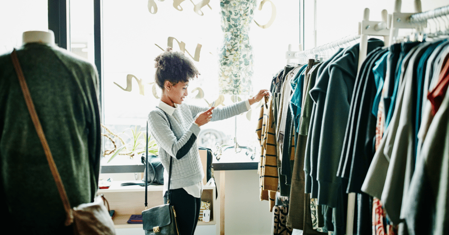 kvinna tittar på en tröja i en klädbutik