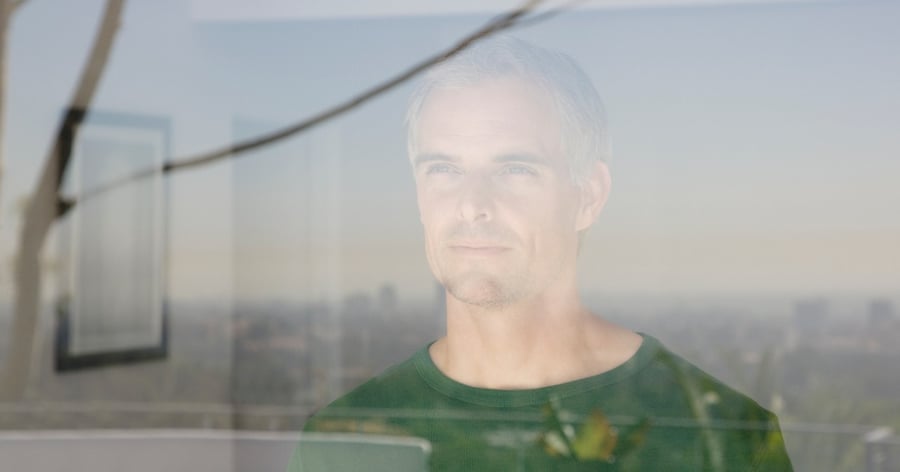 Man tittar ut genom fönster sedd utifrån