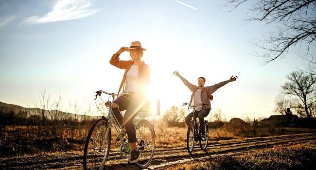 Kvinna och man cyklar på landsväg