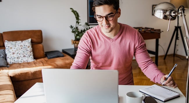 Man med laptop i vardagsrum