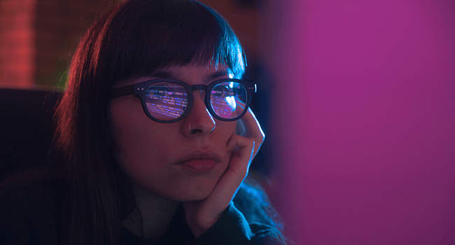 Kvinna med glasögon ser på skärm