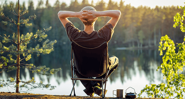 Man sitter och ser ut över sjö