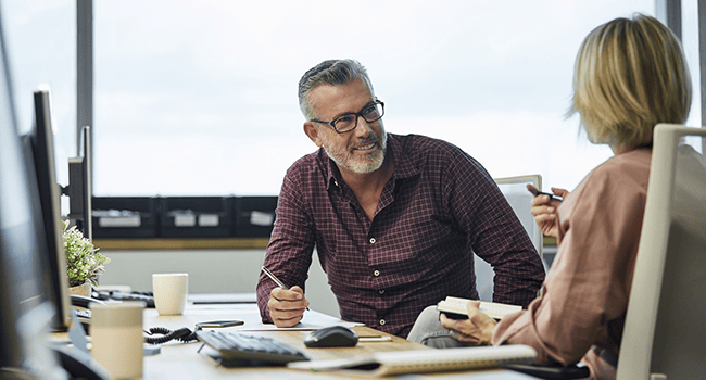Man och kvinna sitter vid ett skrivbord