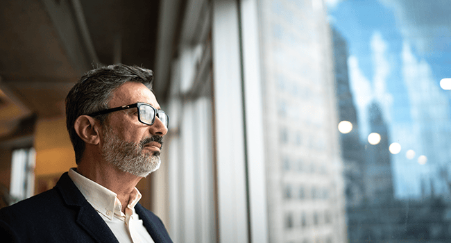 Man tittar ut genom fönster