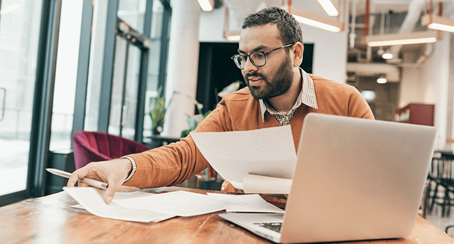Man med dokument och laptop