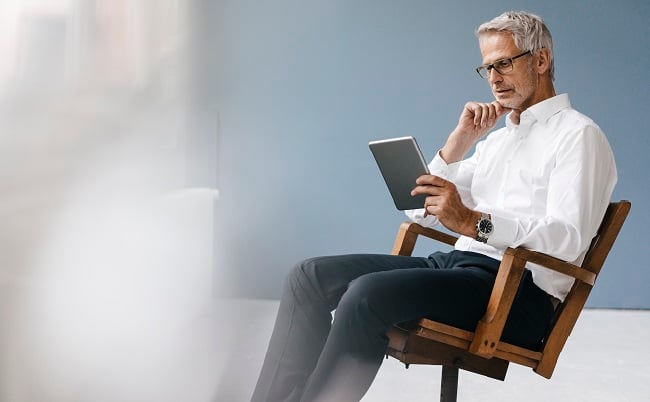 Man i stol med surfplatta