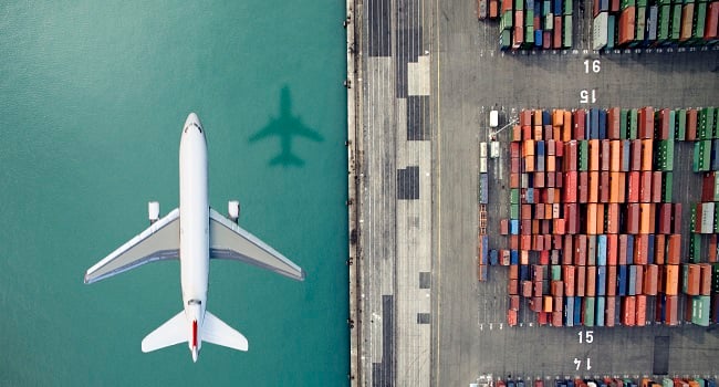 Flygplan över hamn med containrar