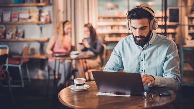 Man vid dator på café